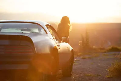 pontiac firebird with woman leaning out of passenger side window