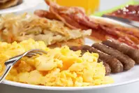 plate of scrambled eggs, sausage and bacon