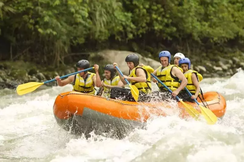 people white water rafting on an orange raft