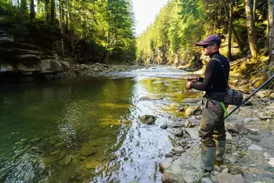 man fishing in a mountain creek