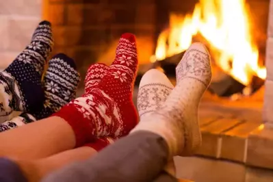 people sitting in a large cabin rental with their feet in front of the fire