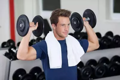 man lifting free weights in exercise facility