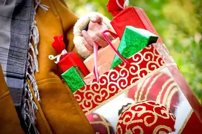 A woman carrying holiday bags on a shopping trip.