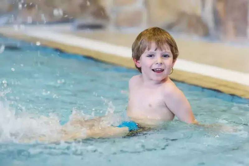 Young boy splashing around in one of our Pigeon Forge cabins with private indoor pools.