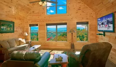 The living room of a Smoky Mountain cabin with plush furniture and scenic views